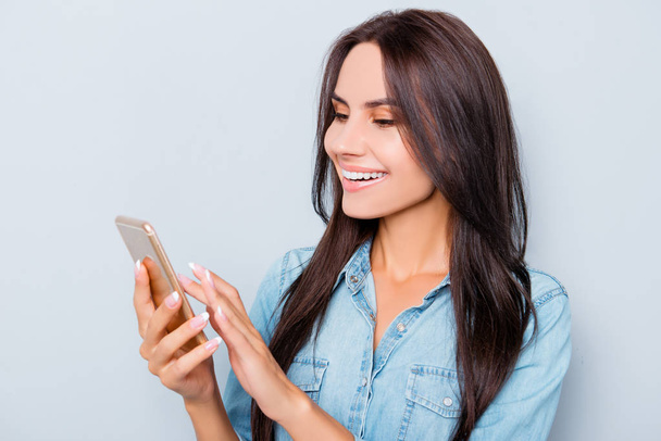 Portrait of happy smiling woman typing sms on smartphone - Foto, afbeelding