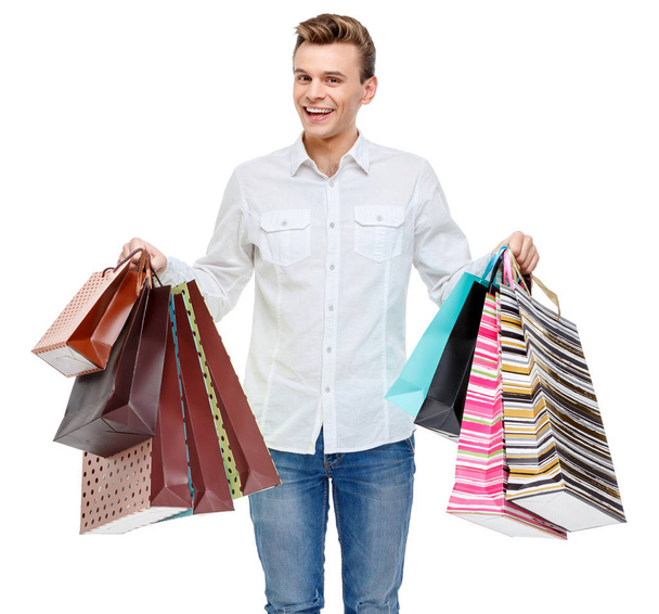 Portrait of young happy smiling man with shopping bags - Foto, afbeelding