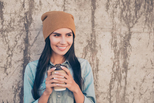 Portrait of beautiful hipster woman in yellow cap drinking coffe - 写真・画像