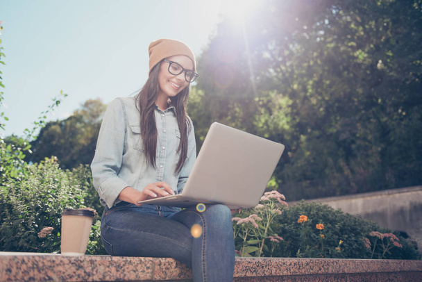 Happy hipster young woman working on laptop in the park - Foto, imagen