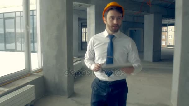Investor inspecting building. Businessman in hard hat inside construction site examining construction progress. - Filmmaterial, Video