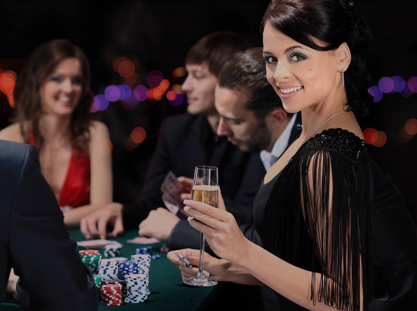 Poker players sitting around a table at a casino - Foto, afbeelding