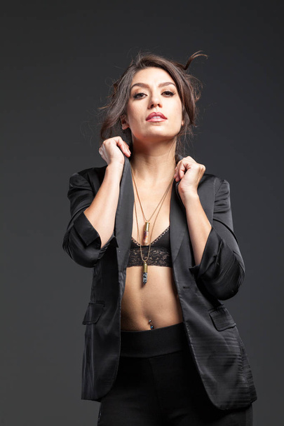 Close Up Hermosa mujer joven posando usando pantalones negros ajustados
  - Foto, Imagen