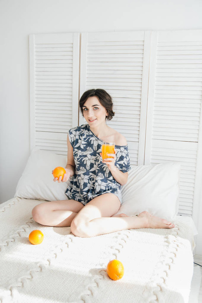 Girl drinking orange juice at Breakfast in bed - Foto, imagen