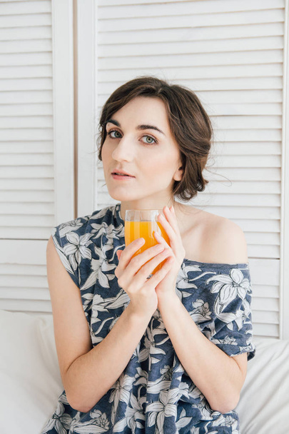 Girl drinking orange juice at Breakfast in bed - Photo, Image