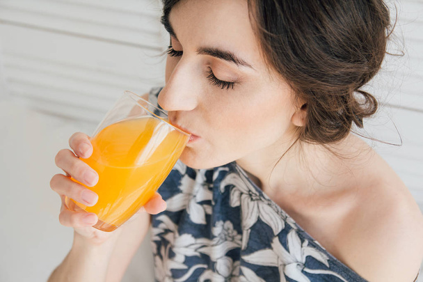 Girl drinking orange juice at Breakfast in bed - Foto, Bild