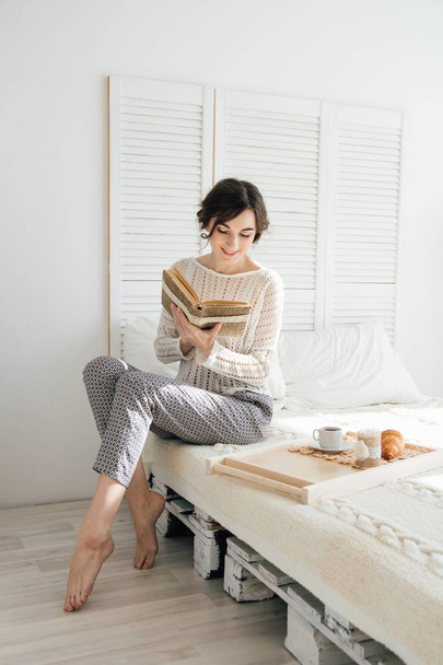 Girl reading a book over Breakfast  - Photo, image