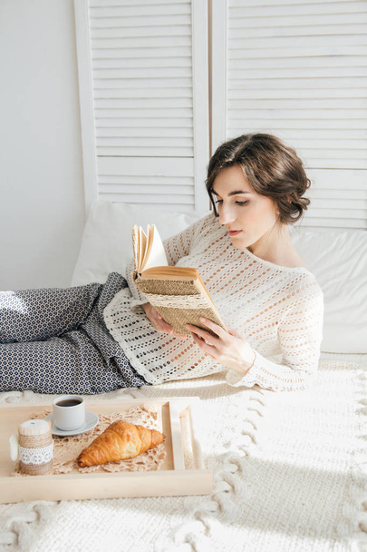 Girl reading a book over Breakfast  - Photo, Image