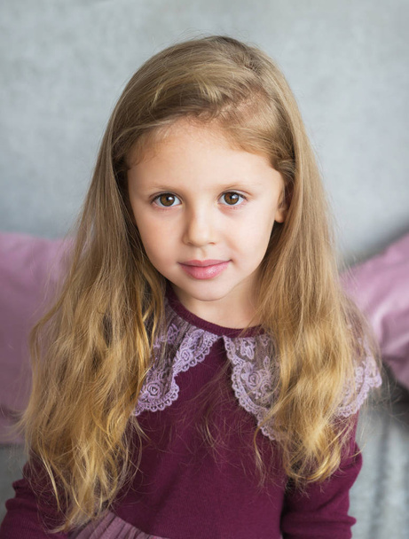 Portrait of pretty little girl in a lilac dress - Photo, Image