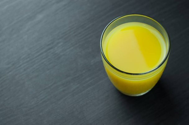 orange juice in glass on wooden background. - Fotó, kép