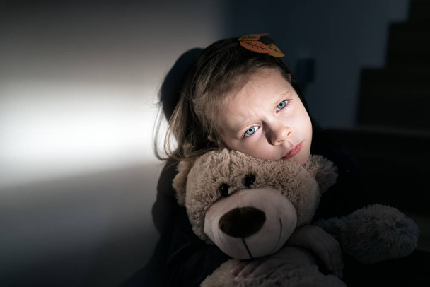 trauriges kleines Mädchen umarmt ihren Teddybär - fühlt sich einsam  - Foto, Bild