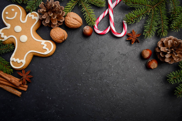Χριστουγεννιάτικο φόντο με κλαδιά έλατου, κώνους, μπαχαρικά και Άρτος αρωματισμένος με τζίντζερ - Φωτογραφία, εικόνα