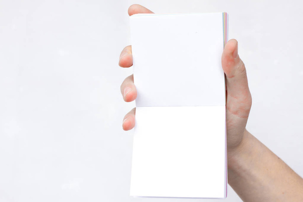 Рука держит блокнот открытым. Чистая белая бумага. Место для надписи
 - Фото, изображение