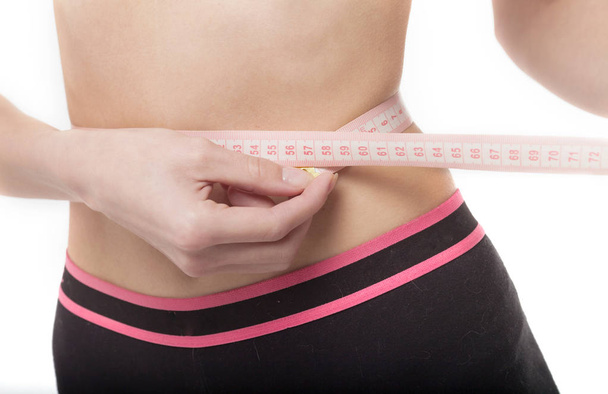 Mulher medindo seu corpo magro sobre fundo branco. Conceito de saúde
. - Foto, Imagem