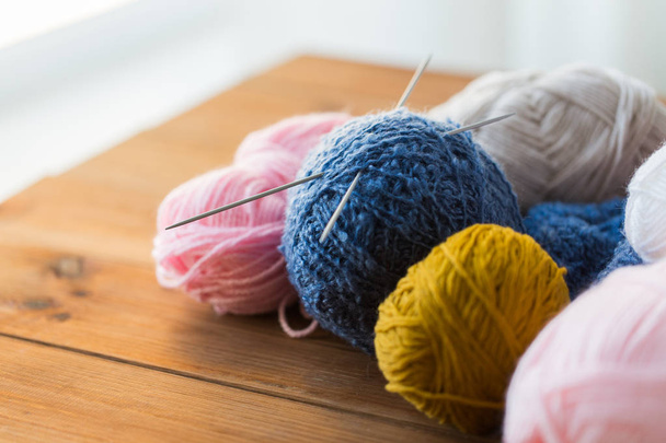 knitting needles and balls of yarn on wood - Фото, изображение