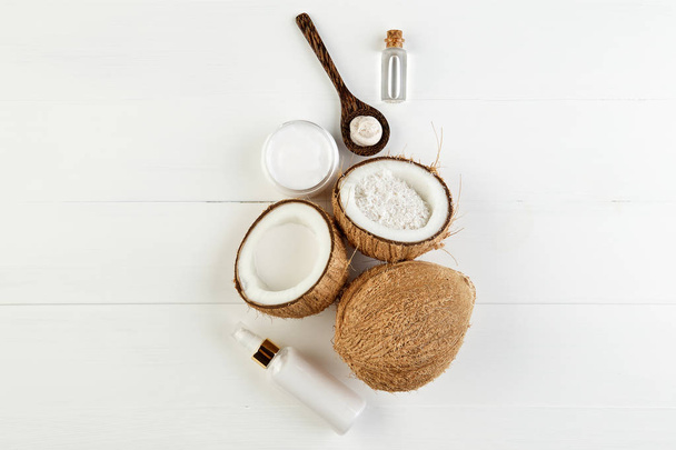 Homemade coconut products on white wooden table background. Oil, - Φωτογραφία, εικόνα