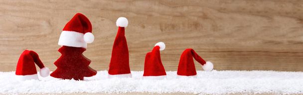 Santa Claus hoeden en red fir tree op de sneeuw. - Foto, afbeelding
