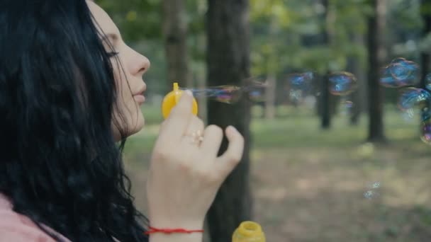 girl blowing bubbles outdoors closeup - Video