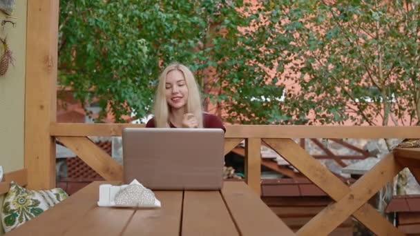 Mladá žena mluví o skype pomocí přenosného počítače - Záběry, video