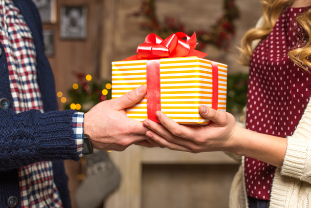 Paar hält Weihnachtsgeschenk in Händen - Foto, Bild