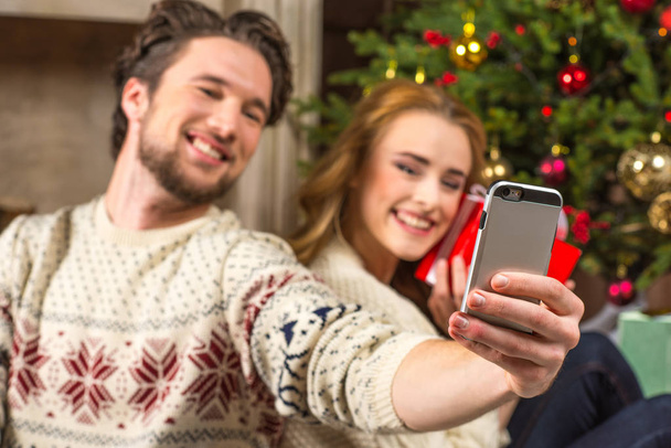 Pareja tomando selfie con regalo de Navidad
 - Foto, Imagen