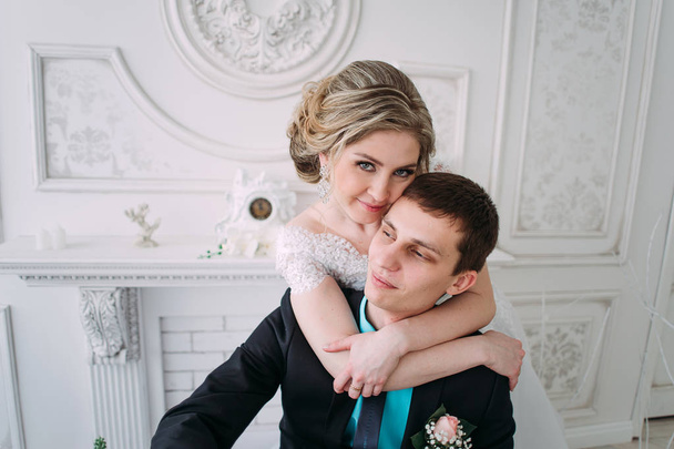 Happy couple. Wedding photo shoot in the white studio with wedding decor kisses, hugs - Valokuva, kuva