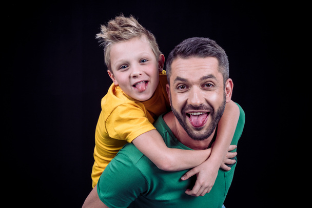 Smiling father piggybacking son - Fotoğraf, Görsel