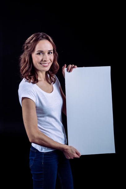 Femme souriante tenant une carte blanche
 - Photo, image