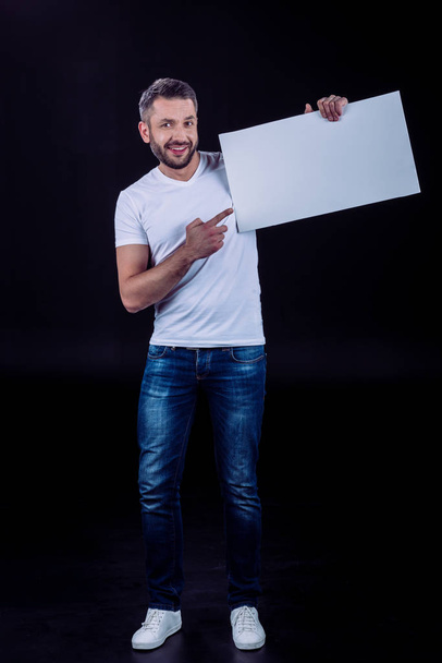 Homme souriant tenant une carte blanche
 - Photo, image