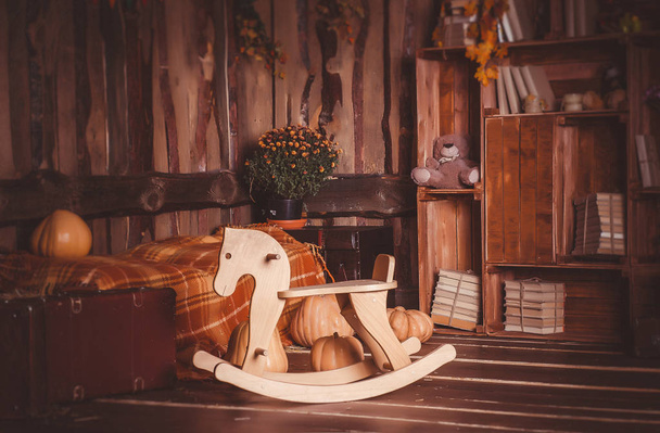 Осенний декор в студии с лошадиным креслом-качалкой
 - Фото, изображение