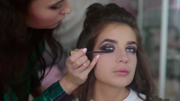 Make up artist applying on mascara on models eyes - Materiał filmowy, wideo