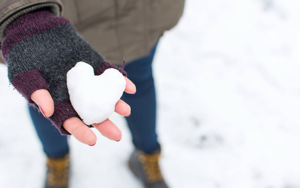 Vrouw handen met hart vormige sneeuwbal - Foto, afbeelding