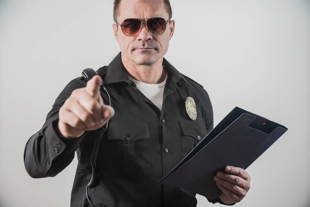 мужчина в полицейском костюме США, указывает пальцем
 - Фото, изображение
