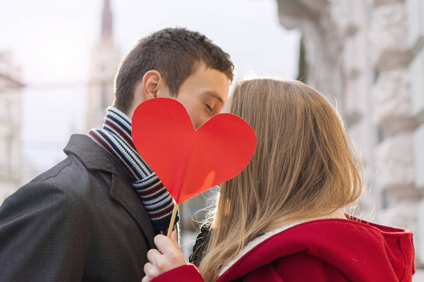 Aşk kırmızı kalp öpüşme içinde genç bir çift. Sevgi ve Sevgililer günü kavramı. - Fotoğraf, Görsel