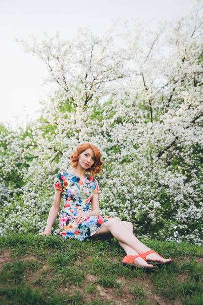 Portrait of beautiful woman in spring blooming garden - Foto, Imagen
