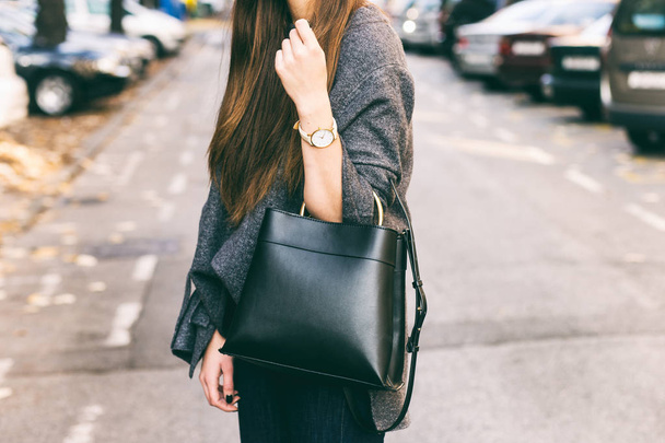 joven mujer de moda sosteniendo su bolso. con joyas doradas y reloj blanco. primer plano detalles de la moda
, - Foto, imagen