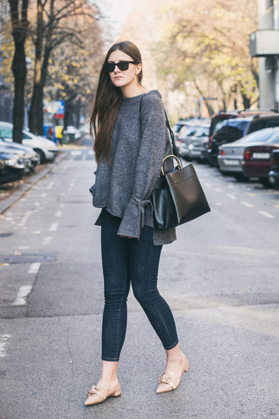 красивая брюнетка моды блоггер позирует на улице. в стильном осеннем наряде. теплый класс, уличный стиль
 - Фото, изображение