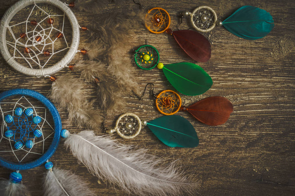 Dream catcher feathers on a dark wooden background, pheasant feathers, duck feathers, chicken feathers - Фото, изображение