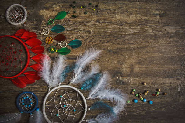 Dream catcher feathers on a dark wooden background, pheasant feathers, duck feathers, chicken feathers - Fotó, kép