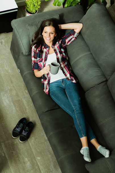 Frau mit Tasse auf Sofa - Foto, Bild