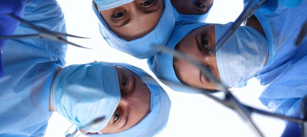 Surgeons team, woman wearing protective uniforms,caps and masks - Foto, Bild