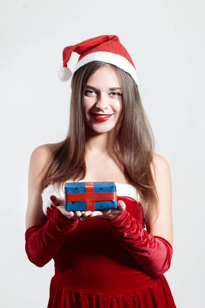 christmas sexy santa girl holding a gift isolated on white background - Foto, imagen