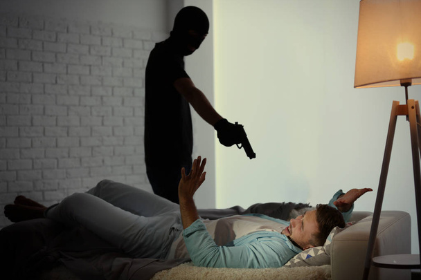 Thief with gun threatening man - Фото, зображення