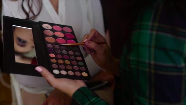 Close-up shot van make-up artiest nemen van eye shadows in make-up palet door borstel - Video