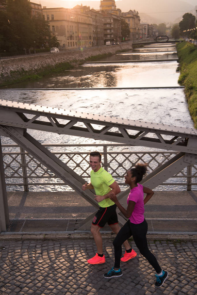 young multiethnic couple jogging in the city - Fotó, kép