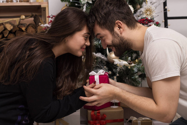 Мужчина дарит подарок девушке на Рождество. Happycouple
. - Фото, изображение