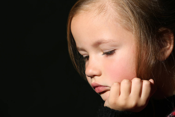 Sad little girl on black background  - Photo, image