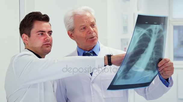 Двоє чоловіків-лікарів дивляться на рентгенівський знімок
 - Кадри, відео