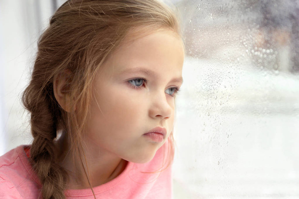  little girl looking out of window - Foto, afbeelding