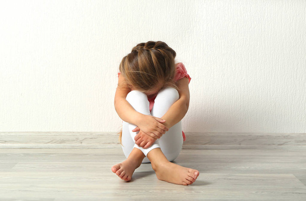 Sad little girl sitting on floor - Photo, Image